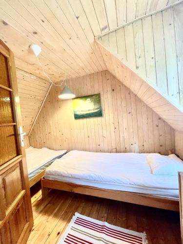 a room with two beds in a wooden cabin at Zagroda Dębki in Dębki