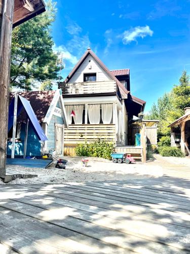 a house sitting on the side of a street at Zagroda Dębki in Dębki