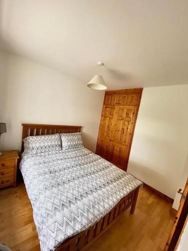 a bedroom with a bed with a wooden headboard at Quiet Farm Cottage Enniskillen Fermanagh in Enniskillen