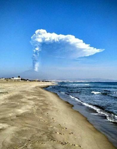a cloud over the ocean with a sandy beach at Villa Capriccio in Villaggio San Leonardo