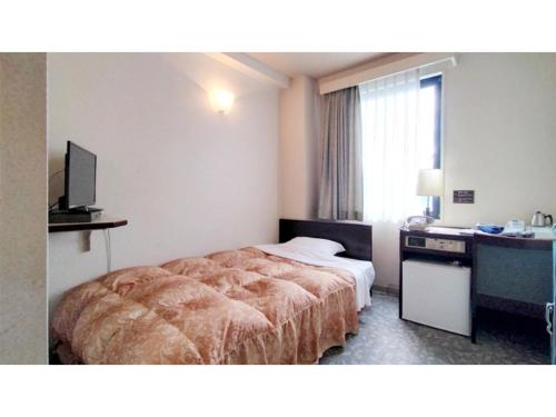 a hotel room with a bed and a desk at Business Inn Suwabe - Vacation STAY 46132v in Kurayoshi