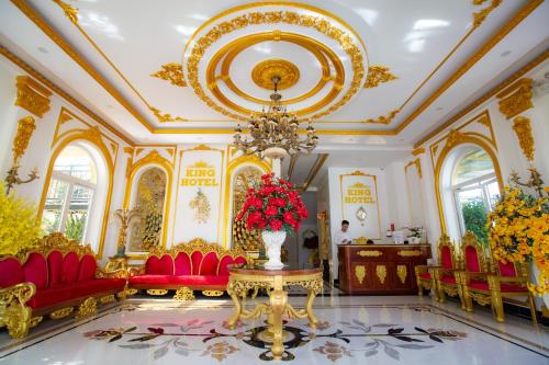 KING VILLA QUẢNG NGÃI في كوانج نجاي: غرفة كبيرة مع كراسي حمراء و إناء من الزهور