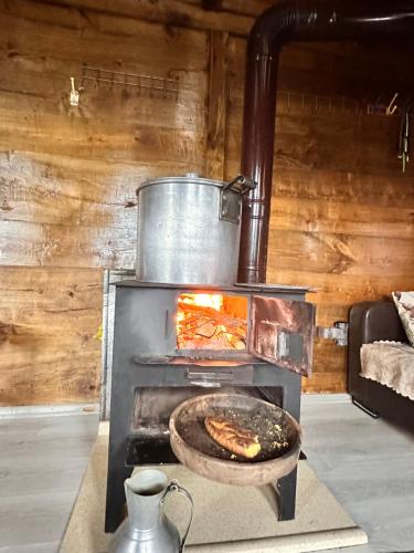 a stove with a pot and a pan of food at أوزونغول Uzongol Fotinos Wooden Cottage Two Bedroom in Çaykara