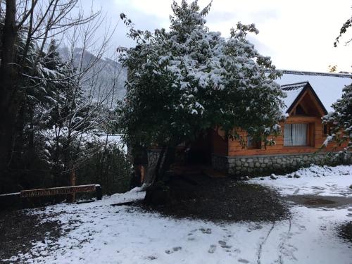 a log cabin with snow on the ground at ABROJITOS in Villa La Angostura