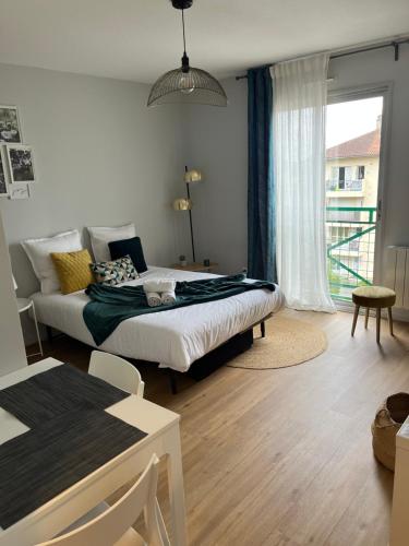 - une chambre avec un lit et une grande fenêtre dans l'établissement Appartement - cœur de Ramonville, à Ramonville-Saint-Agne