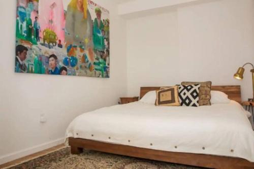 een slaapkamer met een bed en een schilderij aan de muur bij Unique 1BR Greenwich Penthouse Escape! in New York
