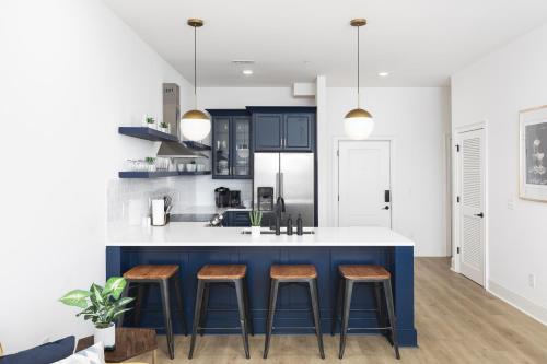 a kitchen with blue and white cabinets and bar stools at Tranquil Haven Close to Broadway with Free Parking in Nashville