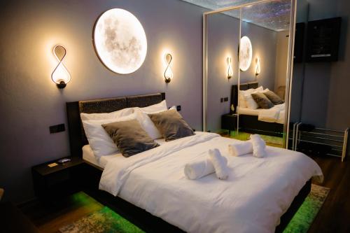 ein Schlafzimmer mit einem großen Bett, auf dem zwei Teddybären liegen in der Unterkunft Relaxveld Galaxy in Curtea de Argeş