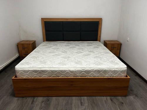 a bed in a bedroom with a wooden bed frame at 1Cosy apartment near airport EVN in Yerevan