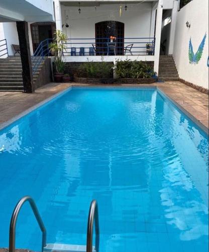 uma grande piscina azul com água azul em Beijaflor Pousada em Corumbá