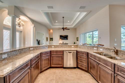 a large kitchen with wooden cabinets and a large counter top at Villa Mayfair, Cape Coral in Cape Coral