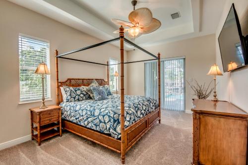 a bedroom with a canopy bed and a fan at Villa Mayfair, Cape Coral in Cape Coral