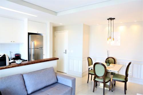a kitchen and dining room with a couch and a table at Apartamento 1903 no Bosque com quarto cozinha completa e vaga de garagem in Campinas
