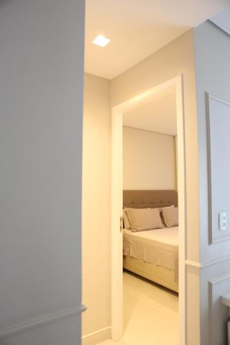 a bedroom with a bed and a mirror at Apartamento 1903 no Bosque com quarto cozinha completa e vaga de garagem in Campinas