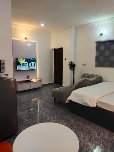 um quarto de hotel com duas camas e uma televisão de ecrã plano em Kemzie's Apartments em Port Harcourt