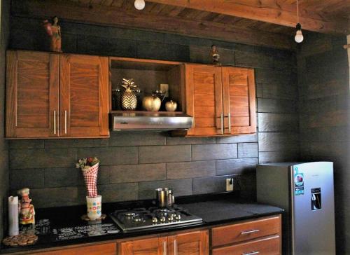 a kitchen with wooden cabinets and a stainless steel refrigerator at Casa Nantly Patzcuaro in Pátzcuaro