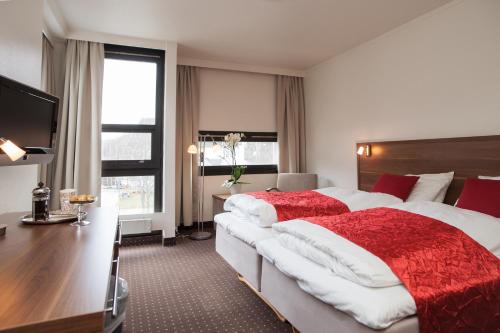 una camera d'albergo con un grande letto e una scrivania di Thon PartnerHotel Otta a Otta