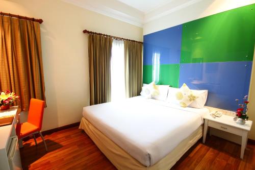 a hotel room with a bed and a desk and a chair at Calypzo Bangkok in Bangkok
