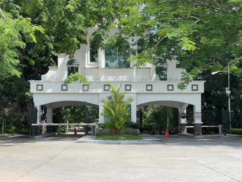 a white building with an arch in front of it at 14F Luxury Resort Lifestyle Ocean Views in Playa Bonita Village