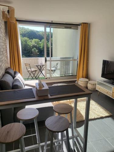 a living room with a table and stools at Pépite entre Paris et Versailles in Chaville