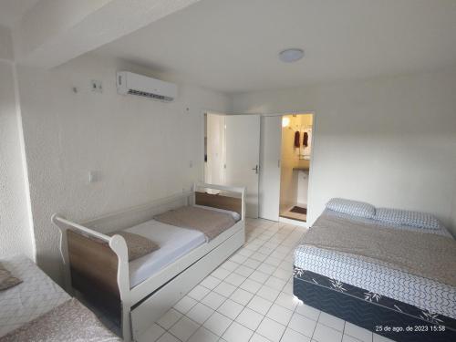 1 dormitorio con 2 camas y puerta a un armario en Aps na praia do Futuro lazer e piscina 2 quartos, Van Cartier, en Fortaleza