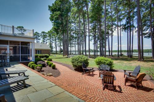 a patio with chairs and tables and trees at Waterfront Cambridge Gem with Hot Tub, Pool and Dock! in Woolford