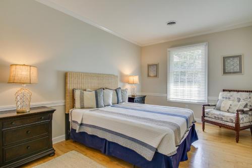 a bedroom with a bed and a chair and a window at Waterfront Cambridge Gem with Hot Tub, Pool and Dock! in Woolford