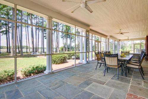 a screened porch with a table and chairs and windows at Waterfront Cambridge Gem with Hot Tub, Pool and Dock! in Woolford