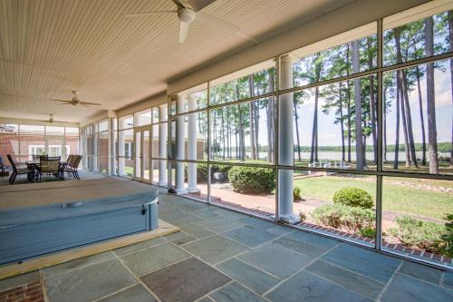 an empty porch with large windows and a table and chairs at Waterfront Cambridge Gem with Hot Tub, Pool and Dock! in Woolford