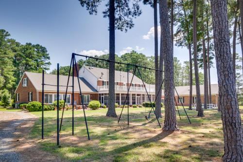a swing set in a park with trees at Waterfront Cambridge Gem with Hot Tub, Pool and Dock! in Woolford