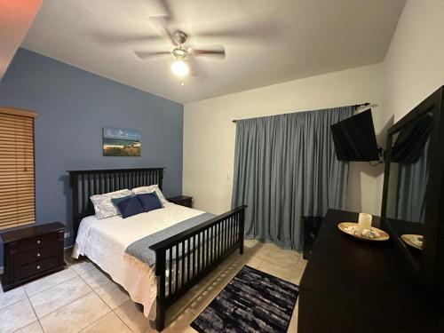 - une chambre avec un lit et un ventilateur de plafond dans l'établissement Tierra Del Sol...OCEAN FRONT GOLF AND TENNIS RESORT CONDO, à Palm-Eagle Beach
