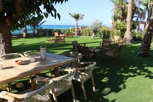 a table and chairs with the ocean in the background at Paradisun Villajoyosa in Villajoyosa