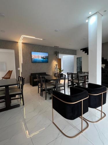 a living room with a dining table and chairs at Colliseu Hotel Pousada in Aparecida