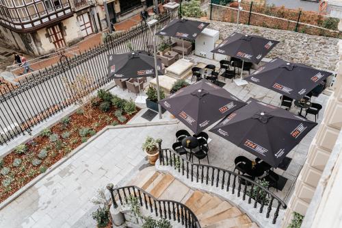 an overhead view of a patio with tables and umbrellas at Hotel Luruna Palacio Larrinaga in Mundaka