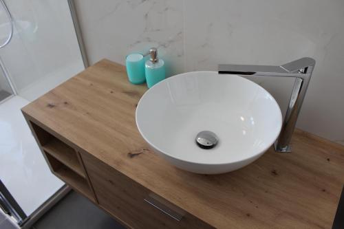 a white sink sitting on a wooden counter in a bathroom at Casa Vanessa in Arezzo