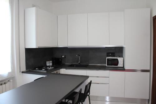 a kitchen with white cabinets and a table and a microwave at Casa Vanessa in Arezzo