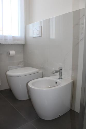 a white bathroom with a toilet and a sink at Casa Vanessa in Arezzo