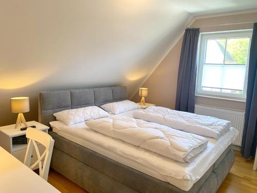 a large bed in a room with a window at Lohme - Doppelhaushälfte Svantevit 2 in Ranzow in Ranzow