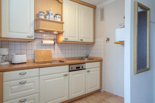 eine Küche mit weißen Schränken und einem Waschbecken in der Unterkunft Skywalker in Westerland