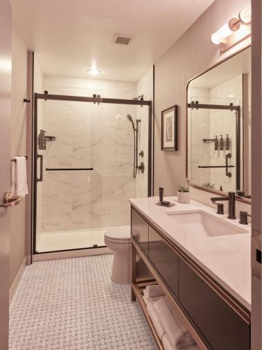 a bathroom with a shower and a sink and a toilet at The Dagny Boston in Boston