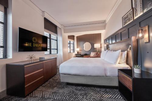 um quarto de hotel com uma cama e uma secretária em The Dagny Boston em Boston