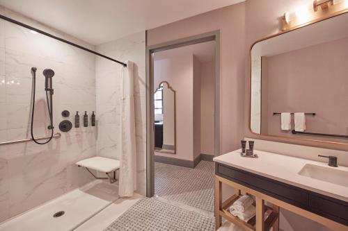 a bathroom with a shower and a tub and a sink at The Dagny Boston in Boston
