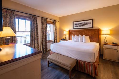 a hotel room with a large bed and a desk at The Lodge at Mountaineer Square in Mount Crested Butte
