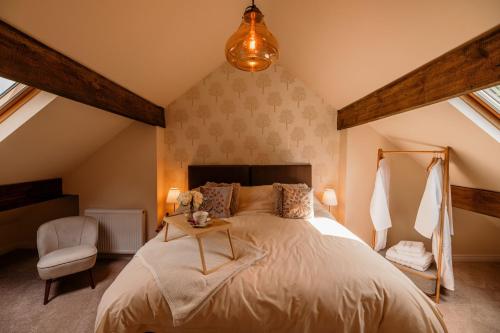a bedroom with a large bed and a chair at George's Cottage in Bamford