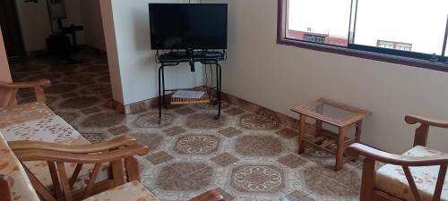 een woonkamer met een flatscreen-tv en een vloer bij Travelershouse Casa Hospedaje in Huanchaco