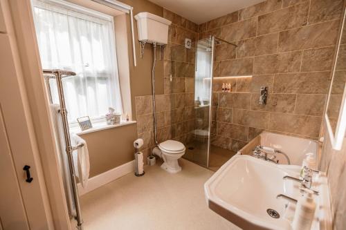 ein Badezimmer mit Waschbecken, Toilette und Dusche in der Unterkunft George's Cottage in Bamford