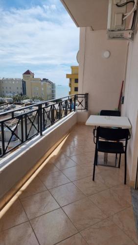 einen Balkon mit einem Tisch und einem Stuhl auf einem Gebäude in der Unterkunft Ledi Home in Durrës