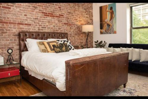 1 dormitorio con cama y pared de ladrillo en Prime Studio Greenwich Village! en Nueva York