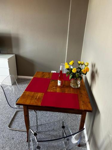 ein Holztisch mit einer Vase mit Blumen darauf in der Unterkunft Traumhafter Altbaucharme in zentraler Lage in Kiel