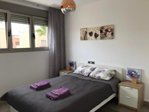 a bedroom with a bed with purple pillows on it at Willa wakacyjna in Torre de la Horadada